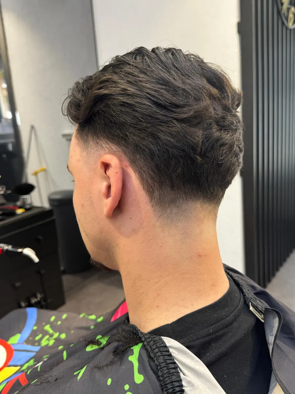 Herrenschnitt von hinten, langes texturiertes Deckhaar, tiefer Übergang im Nacken.